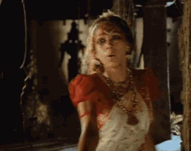 a woman in a red dress is standing in a room