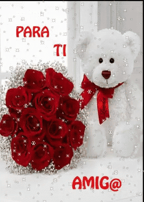 a white teddy bear is sitting next to a bouquet of red roses ..