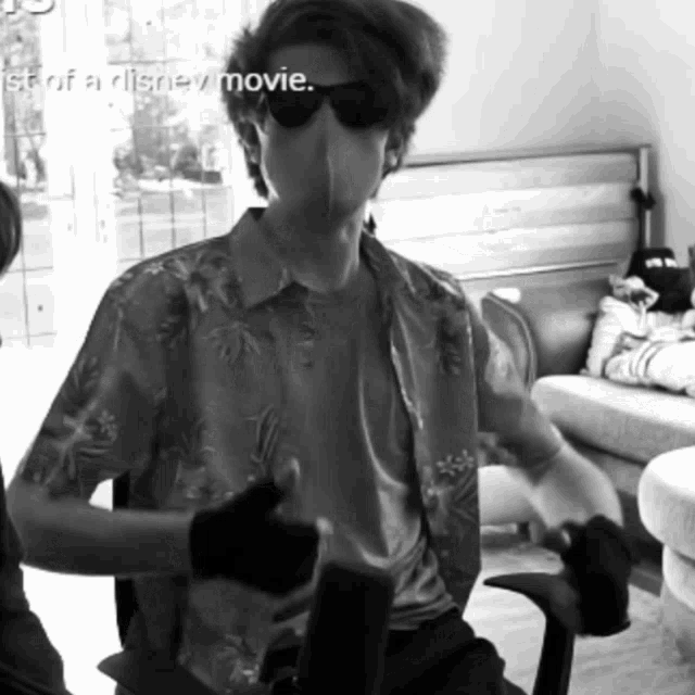 a man wearing sunglasses and a shirt that says stop of a disney movie is giving a thumbs up