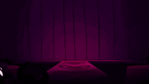 a close up of a person 's face with a purple background and a purple light behind them .