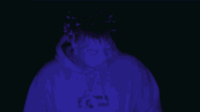 a person wearing a hoodie that says supreme on the front