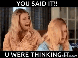 two blonde women are sitting next to each other on a couch and talking .
