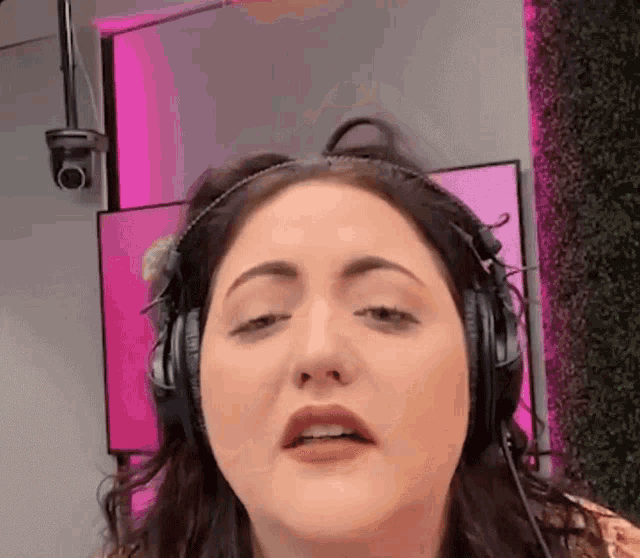 a woman is wearing headphones and making a funny face .