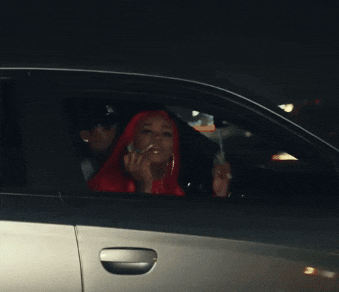 a woman with red hair is sitting in a car