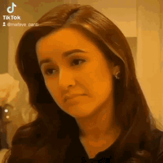 a woman with long hair is making a funny face .
