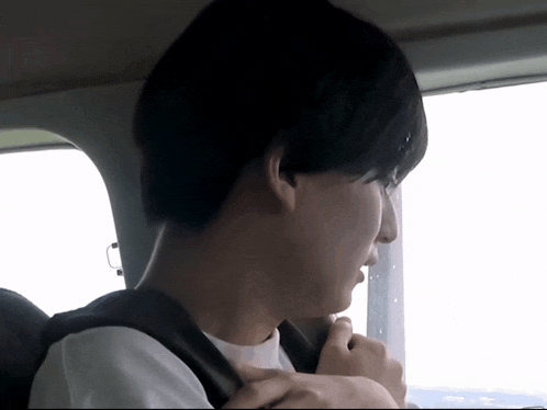 a man is sitting in a car with a backpack on his back