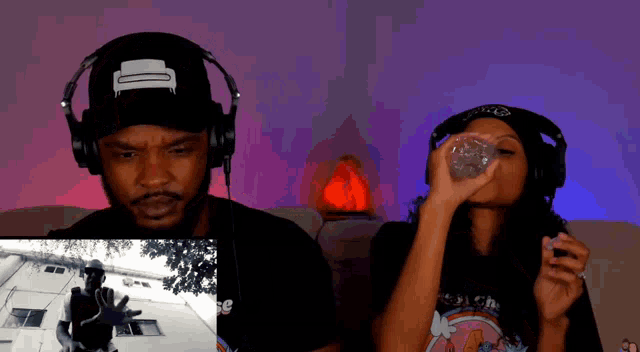 a man and a woman are sitting on a couch with headphones on .
