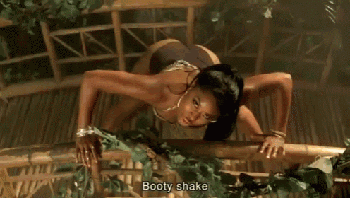 a woman in black shorts is dancing with a snake behind her .