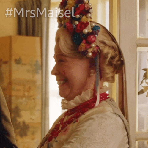 a woman wearing a flowered headpiece with the hashtag #mrsmaisel