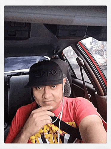 a man wearing a red shirt and a black hat with the word expo on it