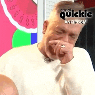 a man is covering his mouth with his hand in front of a watermelon .