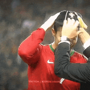a man wearing a red nike shirt is being congratulated by another man