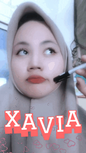 a woman wearing a hijab with the name xavia written on her face
