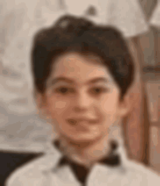 a young boy is wearing a white shirt and a black tie .
