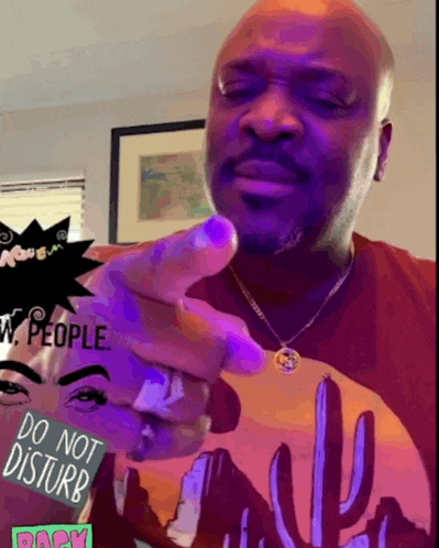 a man wearing a shirt that says do not disturb is pointing at the camera