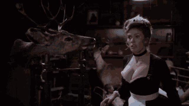 a woman standing in front of a stuffed deer
