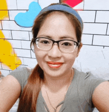 a woman wearing glasses and a headband is smiling
