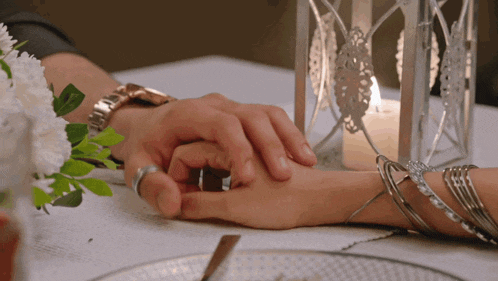a man and woman are holding hands at a table