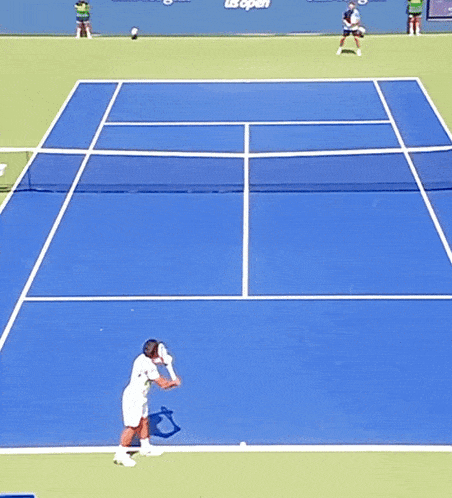 tennis players on a court with us open written on the wall