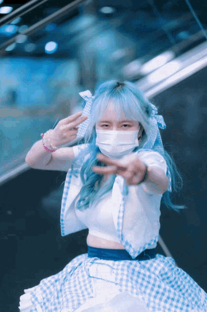 a girl with blue hair wearing a white mask and a blue and white checkered skirt