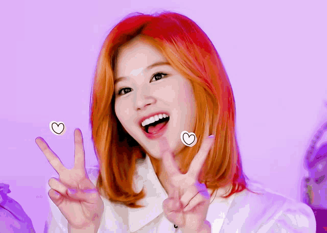 a woman with red hair making a peace sign