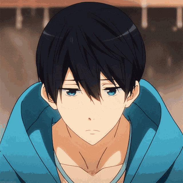 a boy with black hair and blue eyes is wearing a blue sweater