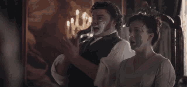 a man and a woman wearing face masks are clapping