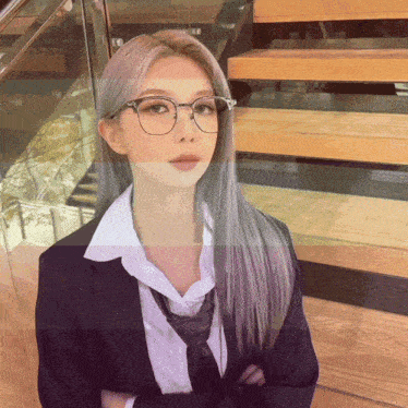 a woman wearing glasses and a suit stands in front of some stairs