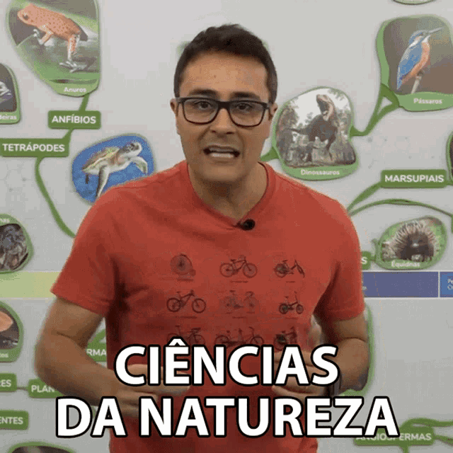 a man wearing glasses stands in front of a poster that says ciencias da natureza on it