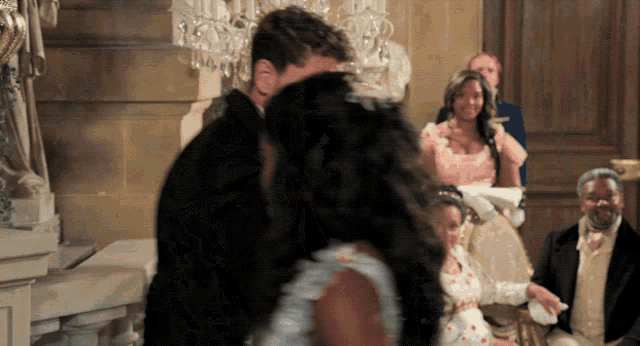 a man and a woman are dancing in front of a crowd of people