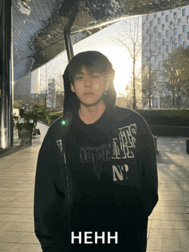 a man wearing a black hoodie with the letter n on the front