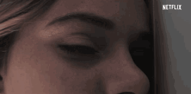 a close up of a woman 's eye with netflix written on the bottom