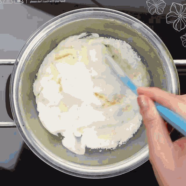 a person is stirring something in a pot with a spatula