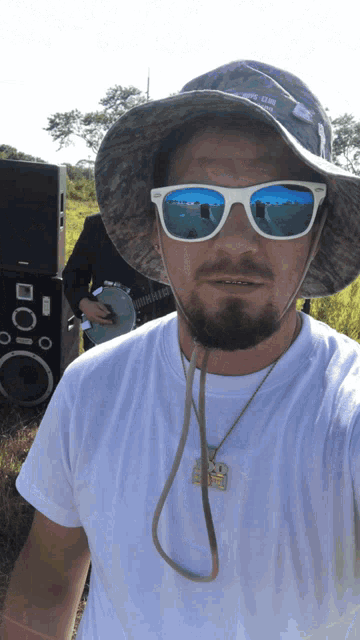 a man wearing a hat and sunglasses has a necklace around his neck that says ' snoop dogg '