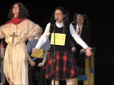 a girl in a plaid skirt is wearing a yellow tag that says 157