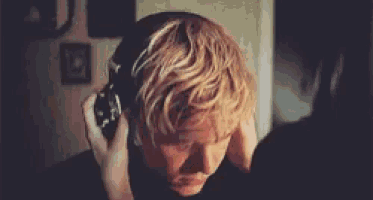 a young man wearing headphones is making a funny face .