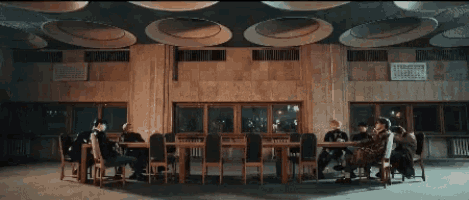 a group of people are sitting at tables in a room