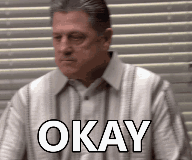 a man in a white shirt has the word okay written on his shirt