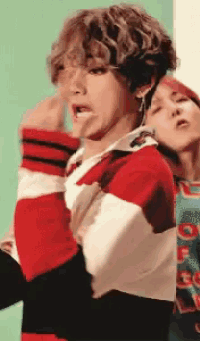 a man wearing a red white and black striped sweater is sticking out his tongue