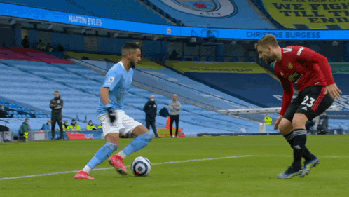 a soccer player in a city jersey kicks the ball