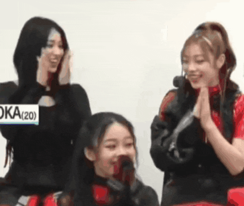a group of young women are sitting next to each other and smiling .