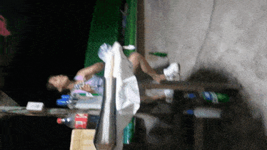 a woman sits at a table with a bottle of coca cola on it