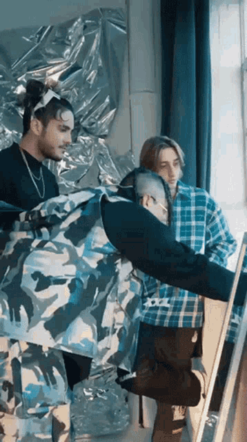 a man in a camouflage jacket looks at himself in the mirror