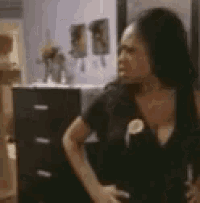 a woman is standing in a room with her hands on her hips .