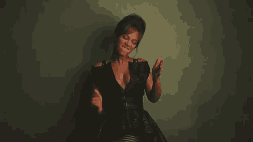 a woman in a black dress is posing for a photo