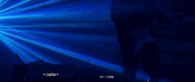a man is playing a guitar in a dark room with a blue light behind him that says matchless