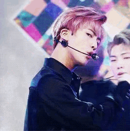 a man with pink hair is wearing a microphone in his ear