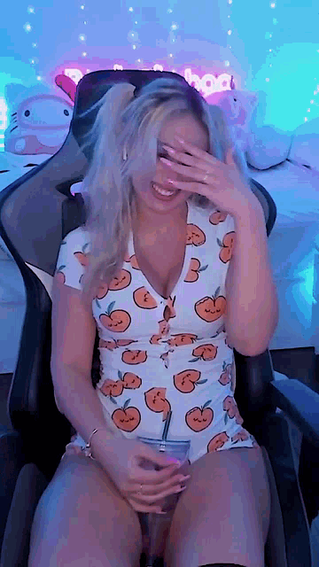 a woman is sitting in a chair covering her face with her hands