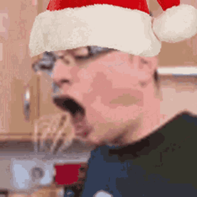 a man wearing a santa hat is making a surprised face