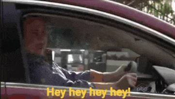 a man is driving a car and says hey hey hey hey